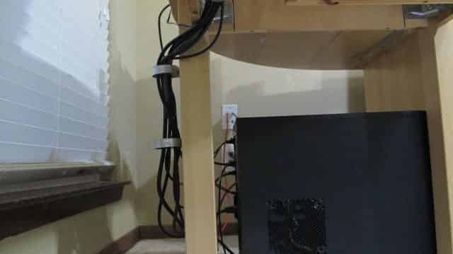 Cables being routed down desk leg to PC