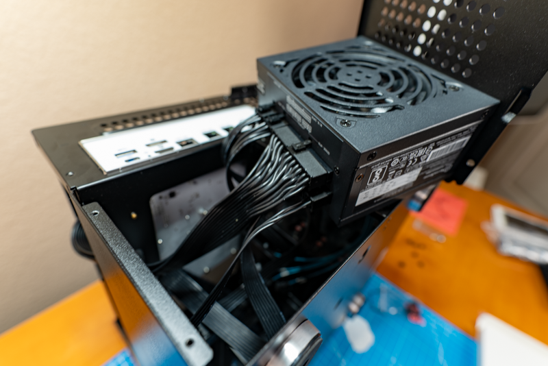 PSU mounted to its installation bracked and about to be installed